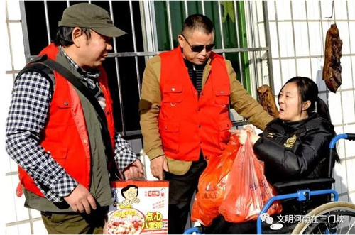 2016年,易海明(左一)到殘疾人朋友家中走訪。圖片來(lái)源:株洲文明網(wǎng)