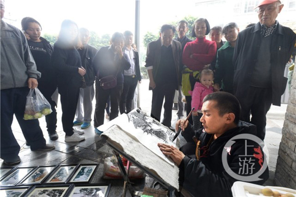 唐昌映在街邊作畫。