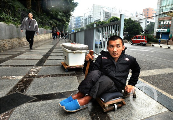 唐昌映坐在滑板車上一步步前行。