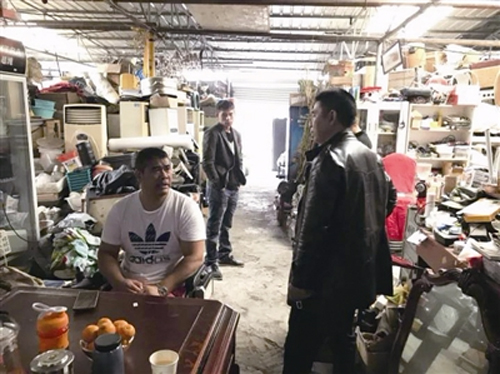 李振虎坐在輪椅上和客商談生意