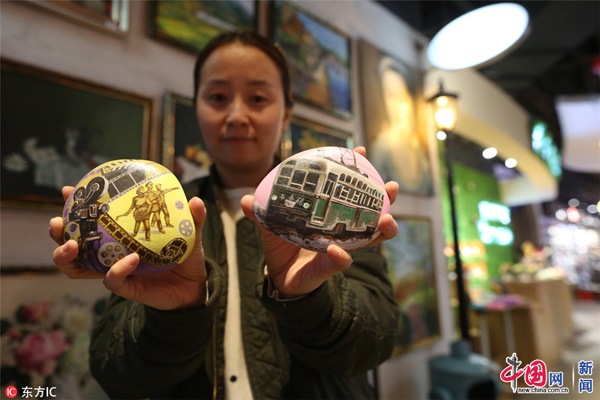 圖為趙娜展示自己創(chuàng)作的石頭畫(huà)作品。白石/東方IC