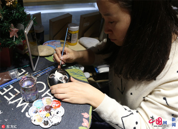 圖為趙娜正在一塊石頭上畫(huà)一只小狗。白石/東方IC