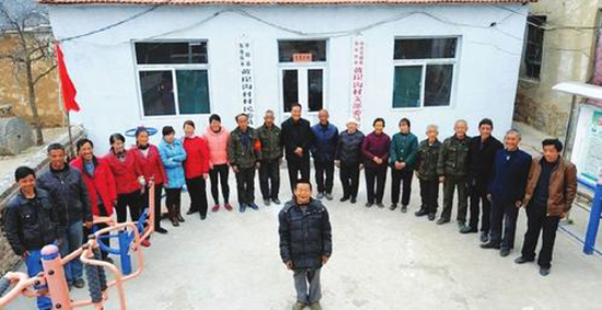 秦海松(前)與照顧他的部分村民在一起。