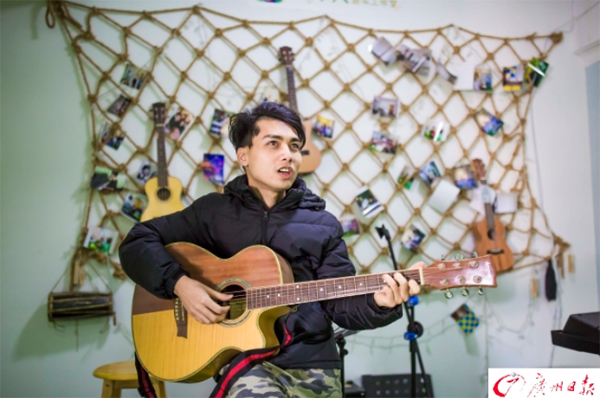 陳偉杰在工作室中彈吉他唱歌。