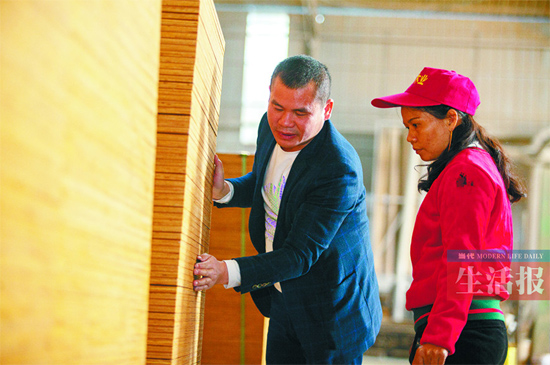 潘甲貴通過觸摸和敲打檢查木材加工半成品