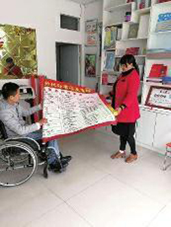 何繼偉和妻子正在查看剛打印出來的宣傳廣告