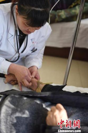 山西省太原市小店區(qū)中心敬老院醫(yī)師樊彩風(fēng)正在為老人檢查身體。　趙娟 攝