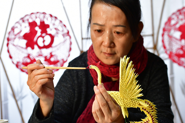 1月3日，在河南省鄭州市的家中，蔡建華在制作紙雕作品《鳳凰》。