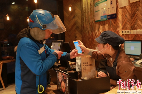 外賣小哥朱仲銀在商家取外賣。中國青年報·中青在線見習記者 楊威/攝