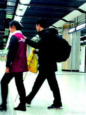 圖為：夏婷為盲人乘客帶路的情景（市民抓拍）