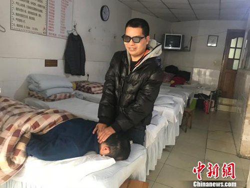 黃訓忠在按摩店為顧客提供推拿按摩服務。魏堯攝