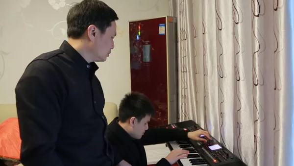 父親(左)輔導王子安練琴