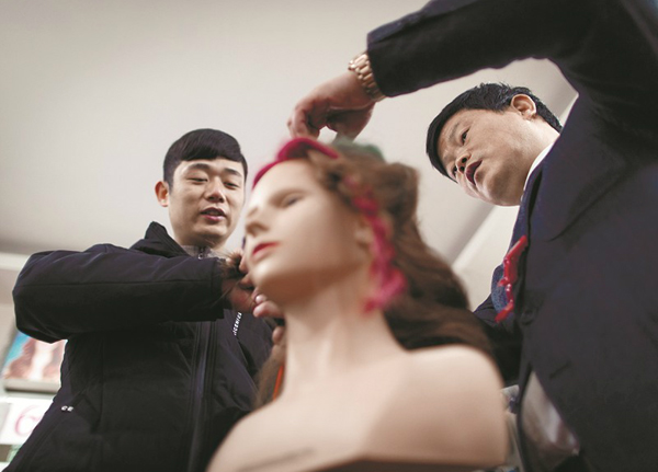 圖為手把手為殘疾徒弟們做示范。