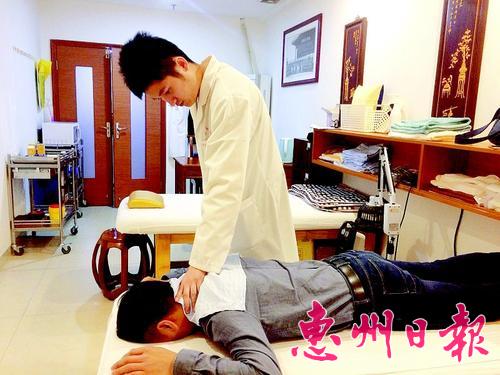 吳嘉威在給患者推拿。